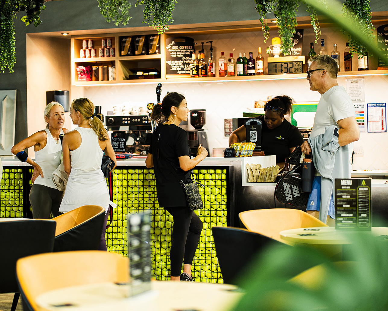 Players with rackets in the club cafe and bar